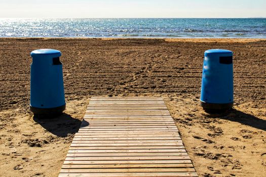 Wastebaskets and walkway to the beach in the morning