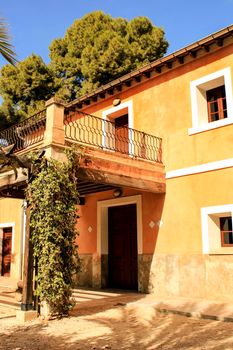 Elche, Spain- 14 February, 2018: Typical and colorful house in a palm orchard in Elche, Spain on a sunny day. Huerto de San Placido.