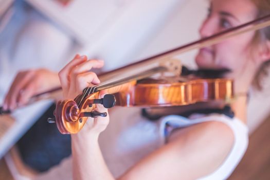 Pretty young girl practices on her violin, acoustic music