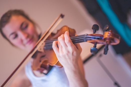 Pretty young girl practices on her violin, acoustic music