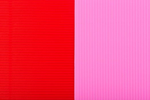 Red and pink background with stripes. Paper textured backdrop. Abstract colorful wallpaper. Corrugated red and pink paper