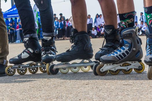 Three skaters are standing on the street