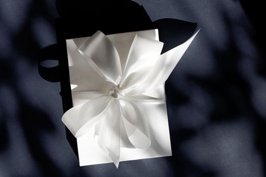 Anniversary celebration, shop sale promotion and luxe surprise concept - Luxury holiday white gift box with silk ribbon and bow on black background, luxe wedding or birthday present