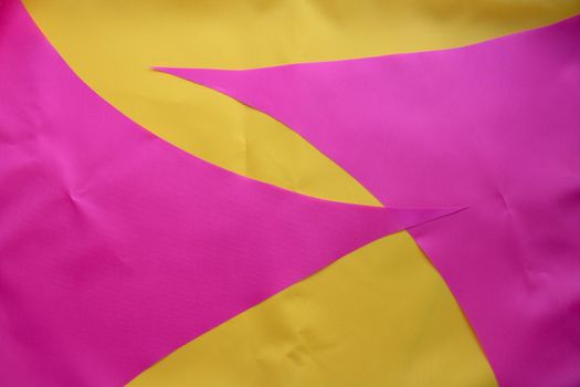 Pink pieces of fabric lie on the yellow fabric.