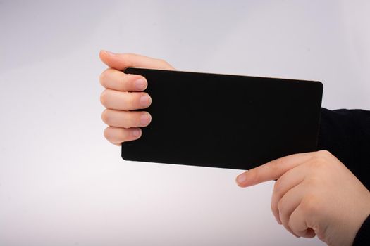 Rectangular shaped black notice board in hand on white background