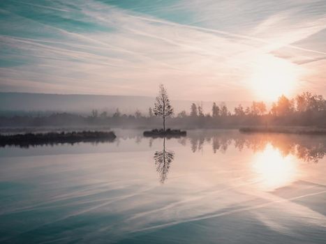 Chalupska slat lake at Borova lada, classic shot during a bright and vibrant pink and blue sunrise with foggy background. Chalupska Moor Lake in Sumava Mountains, Czech Republic