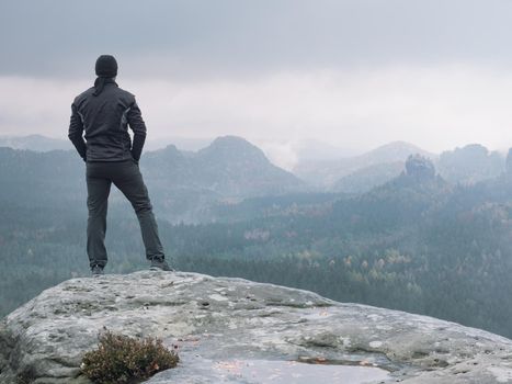 Traveler in the mountains. A man enjoys a beautiful view of the misty mountains. Man at sunrise in the mountains