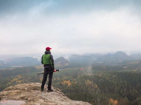 Photographer at misty sunrise. Rainy misty fall day