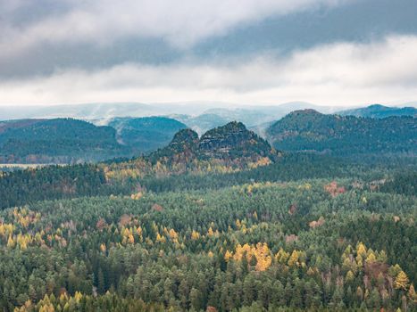 Sunset at Mountains.  Deep valley full of colorful trees within autumn season.