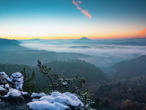 Snowy peak early morning.  Chill awaking in misty country. Morning sun hidden bellow  horizon