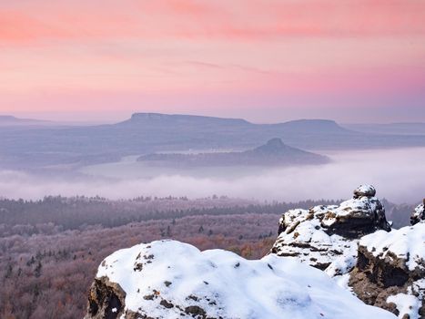 Snowy rocks above valley in Saxony Switzerland national park. Elbe river valley in chill morning