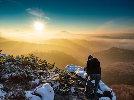 Nature photographer taking photos in the snowy mountains. Amazing winter morning