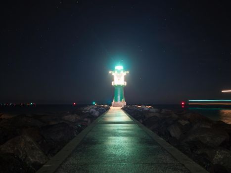 Bright light of Green and white breakwater lights at harbor entrance in Rostock Warnemunde, Germany 