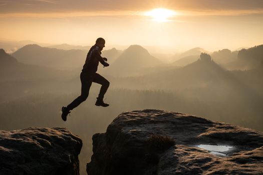 Man jumping over pekas against sky during sunset. Pure excitment in the mountains 