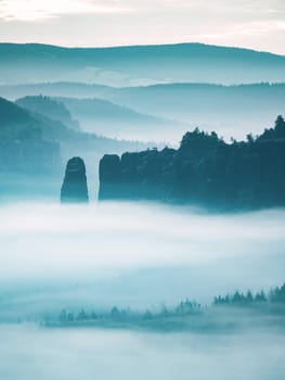 Mountain peak outline in blue night mist.  Row of foggy mountain ranges in Sachsen Deutschland park.