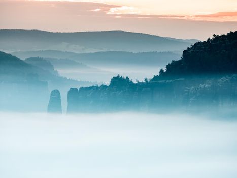 Mountain peak outline in blue night mist.  Row of foggy mountain ranges in Sachsen Deutschland park.