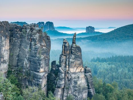 Jagged rocks near Blossstock and Affensteine, in the background the Falkenstein massif in the valley of the evening fog.