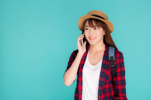 Beautiful young asian woman talking smart mobile phone in vacation isolated on blue background, asia girl conversation on smartphone in travel summer trip, journey and communication  concept.