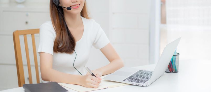 Young asian woman wearing headphone study online with e-learning on desk, girl wearing headset learning to internet with laptop computer at home, new normal, distance education and training.