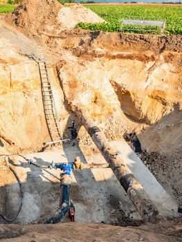 Deep trench in ground to for a large water supply pipeline. Reapiring of drink water supply connection