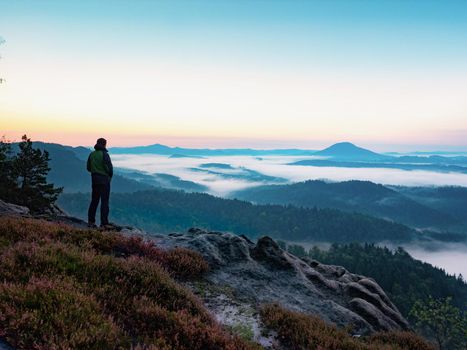 Adventure man looks at the morning horizon in the mountains during an excursion 