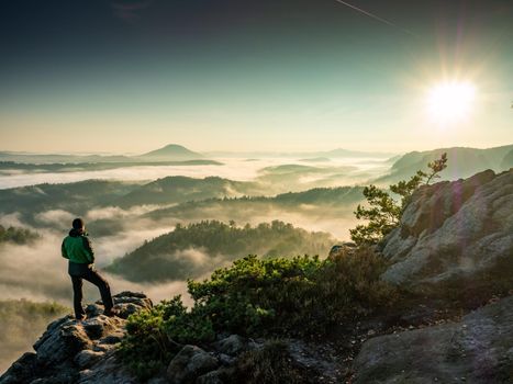 Single man hiker on a mountain trail. Mountain look into misty valley