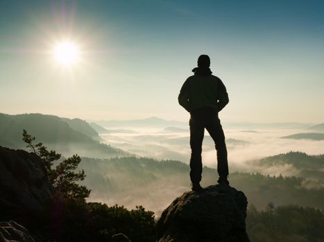 Adventure man looks at the morning horizon in the mountains during an excursion 