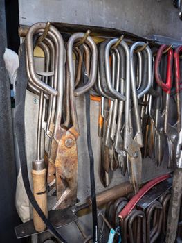 Rack of shaped Glassblowing Diamond Shear Scissors. Detailed glassblower manual tools in workshop