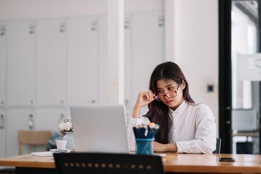 Photo of beautiful asian business lady resourceful person with glasses looking seriously laptop computer watching online training at home office