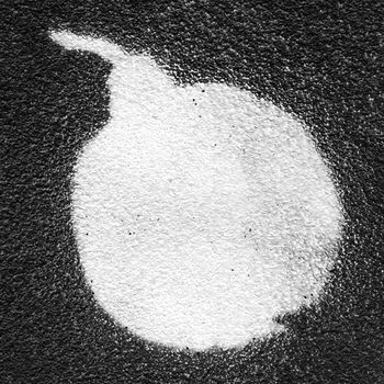 Bomb painted with white paint spray on a black wall.