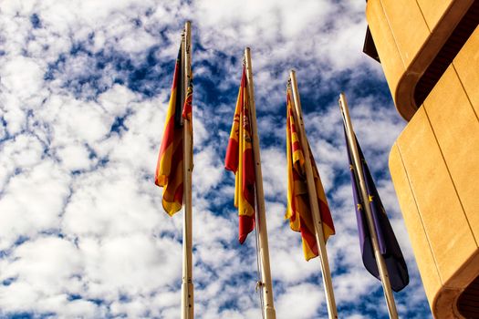 Constitutional flags of Spain and Europe at the city hall in a cloudy day in Santa Pola, Alicante, Spain