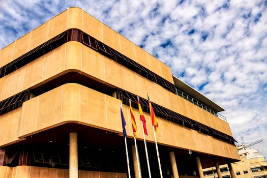 Santa Pola, Spain- February 16, 2018: Constitutional flags of Spain and Europe at the city hall in a cloudy day