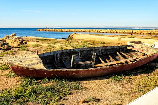 Old abandoned wooden boat on the beach in Santa Pola, Alicante, Spain