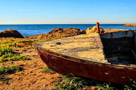 Old abandoned wooden boat on the beach in Santa Pola, Alicante, Spain