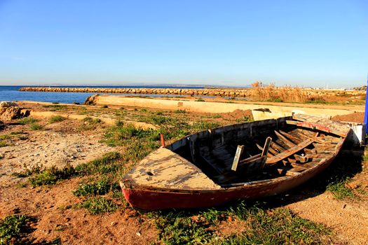 Old abandoned wooden boat on the beach in Santa Pola, Alicante, Spain