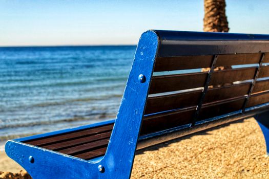 Blue bench with sea view on the beach in southern spain