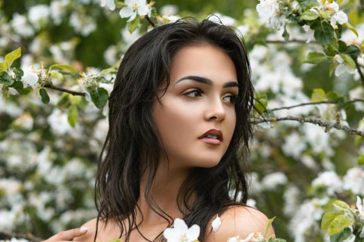 Portrait of a gentle young elegant beautiful girl in the garden near the blossoming apple tree. Youth concept