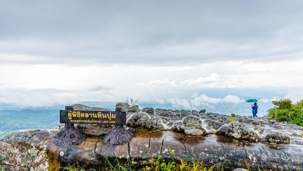 Lan Hin Pum Nameplate tourist group and large stone courtyard while the rain is falling with strange stone shapes is a famous nature attractions of Phu Hin Rong Kla National Park, Phitsanulok,Thailand