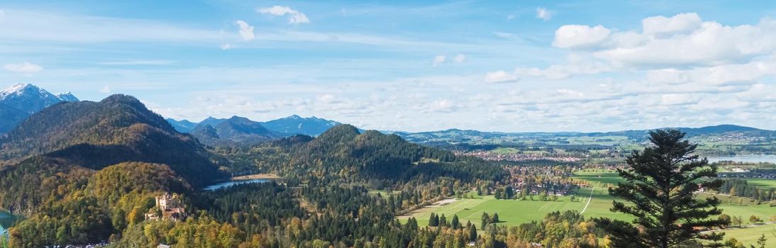 Beautiful nature of European Alps, landscape view of alpine mountains, lake and village on a sunny day, travel and destination scenery