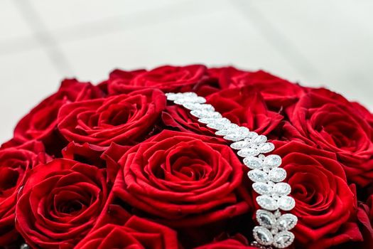 Gemstone jewellery, wedding fashion and luxe shopping concept - Luxury diamond bracelet and bouquet of red roses, jewelry love gift on Valentines Day and romantic holidays present