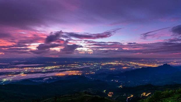 High view beautiful nature landscape of colorful sky during the sunrise see the lights of the road and city at Phu Thap Berk viewpoint, Phetchabun Province, Thailand, 16:9 wide screen