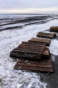 Beach flooded after the storm and broken wooden walkway in Alicante, Spain
