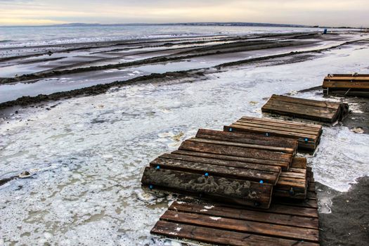 Beach flooded after the storm and broken wooden walkway in Alicante, Spain