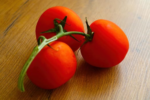 Close-up on a branch of red tomatoes on the table