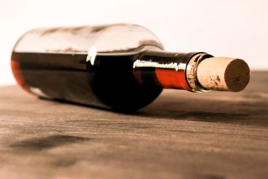 Bottle of red wine on wooden table. White background