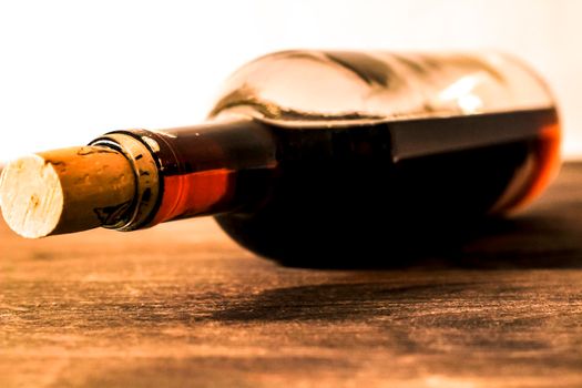 Bottle of red wine on wooden table. White background