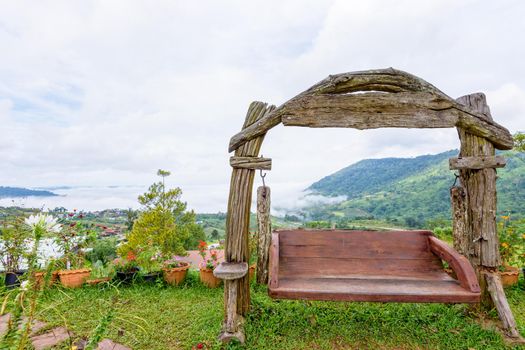 Beautiful nature landscape fog in the valley and swing made of wood on the hill at the high angle viewpoint. Famous tourist attractions at Khao Kho district, Phetchabun province Thailand