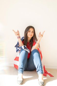 Independence day of the USA. Happy July 4th. beautiful young woman with american flag, prism rainbow reflection on the foreground. Copy space