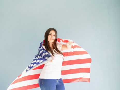 Independence day of the USA. Happy July 4th. beautiful young woman with american flag on blue background