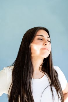 Portrait of beautiful brunette woman with eyes closed with reflection from light prism on her face